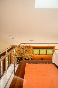 a living room with a staircase and a stone wall at Casa dos Alloques in Paredes de Coura +83 photos