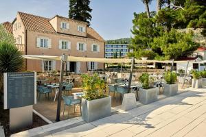 a restaurant with tables and chairs and a building at Sheraton Dubrovnik Riviera Hotel in Mlini