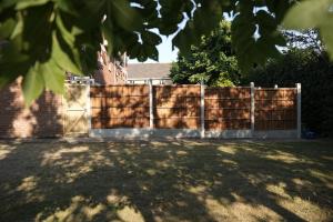 a wooden fence in front of a house at Town Centre spacious 4 bed town house in Saint Neots
