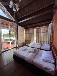 two beds in a room with a large window at Papar Beachfront View in Papar