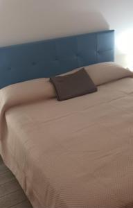 a bed with a brown pillow on top of it at Casa Vacanze Donna Lia in Giardini Naxos