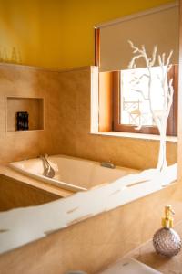 a bath tub in a bathroom with a mirror at Casa dos Alloques in Paredes de Coura