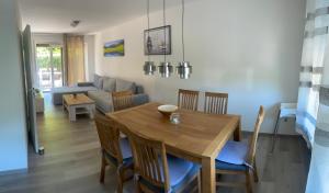 a dining room and living room with a wooden table and chairs at Holunder nah am Waldsee 2 in Rieden
