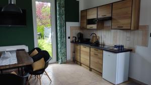 a kitchen with wooden cabinets and a table and chairs at Agroturystyka Wypoczynkowa II in Zieleniewo