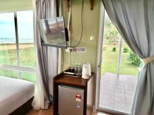 a bedroom with a mirror and a bed and a window at Papar Beachfront View in Papar