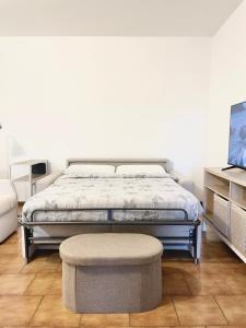 a bedroom with a bed and a stool and a tv at Z37 4bed, terrace, tennis and summer pool, 10 min Milan in Opera +14 photos