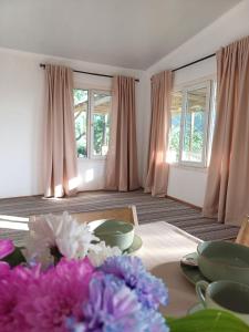 un soggiorno con tende rosa e un tavolo con fiori di Гостевой дом Tengri House a Zhezdi