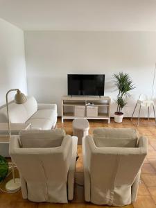 a living room with white furniture and a flat screen tv at Z37 4bed, terrace, tennis and summer pool, 10 min Milan in Opera