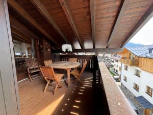a wooden deck with a table and chairs on a balcony at 046 Luminosa Mansarda, Giustino in Giustino