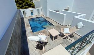 an overhead view of a swimming pool with chairs and tables at Chariot Apartments Santorini in Kamari