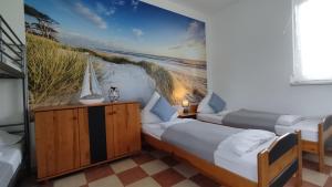 two beds in a room with a beach mural at Agroturystyka Wypoczynkowa II in Zieleniewo +38 photos