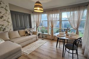a living room with a couch and a table at White Hill's Nest in Zvejniekciems