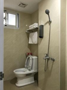 a bathroom with a toilet and a shower stall at 廷海特潮流民宿 漢中館 民宿編號1746 寵物友善陽台房 近微光集與鐵道藝術村 in Taitung City