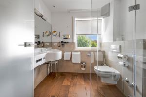 a bathroom with a toilet and a sink and a window at ChiemseeStern Vacation & Recreation Adults Only in Gstadt am Chiemsee +54 photos