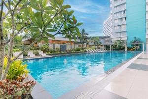 an infinity pool at a hotel with chairs and trees at La Vita by Alfredo 215 in Bacolod