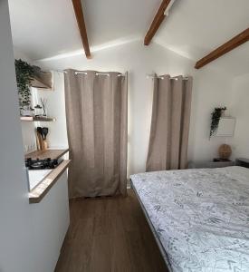 a bedroom with a bed and curtains in a room at Maisonnette cosy à la campagne in Céret