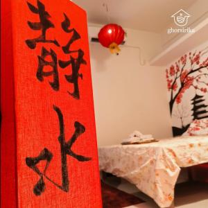 a red rug with chinese writing on it in a room at Natsukashii by Ghorsirika in Guwahati +2 photos