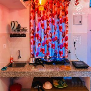 a kitchen counter with a sink and a shower curtain at Natsukashii by Ghorsirika in Guwahati