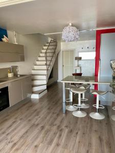 a kitchen with a dining room table and a staircase at Villa Porto vecchio vue mer 5 étoiles piscine parking privé gratuit in Porto-Vecchio +17 photos