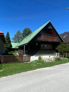 une maison avec un toit verdoyant et une terrasse couverte dans l'établissement Drevenica pod Kráľovou hoľou, à Šumiac 2 autres photos