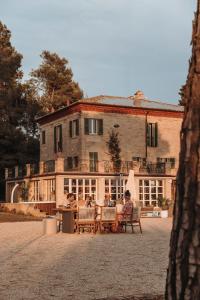 a group of people sitting in chairs in front of a building at Maniero Montecassiano in Montecassiano +26 photos