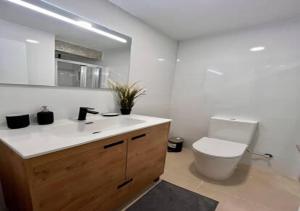a white bathroom with a toilet and a sink at alojamiento near everything in Valencia