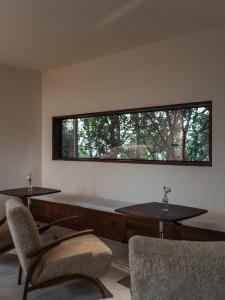 a room with two chairs and a large window at Rediscover Mountain Lodge - Nanshan, Chongqing in Chongqing