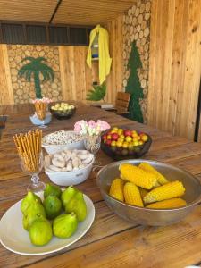 a wooden table with bowls of fruit and vegetables on it at Art House in Yerevan
