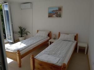 two twin beds in a room with a window at Jezero in Potokovići