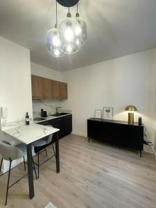 a living room with a table and a kitchen at Appartement hyper-centre Rodez in Rodez