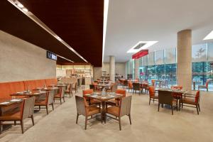 a dining room with tables and chairs in a restaurant at Courtyard by Marriott Kochi Airport in Nedumbassery