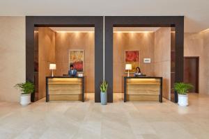 a lobby with two people sitting at reception desks at Courtyard by Marriott Kochi Airport in Nedumbassery