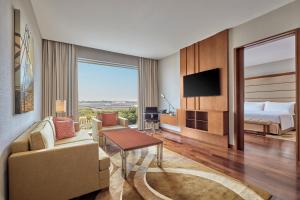 a hotel room with a bed and a living room at Courtyard by Marriott Kochi Airport in Nedumbassery