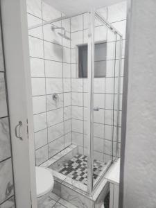 a bathroom with a glass shower with a toilet at Hayley's inn at village blues in Johannesburg +12 photos