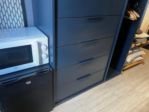 eine blaue Kommode mit Mikrowelle und Schublade in der Unterkunft Cozy Boutique hotel-Guesthouse Leuven -self check in in Löwen