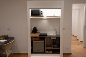 a kitchen with a counter and a microwave on a shelf at G&G Luxury Rooms in Bari +32 photos