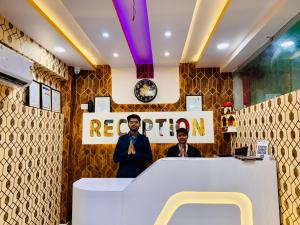 two men standing at a counter in a room at Hotel Golden Crystal Best Hotel in kankarbagh Patna in Patna