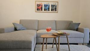 a living room with a couch and a glass of wine at La Maison de l'ile Bora in Policoro