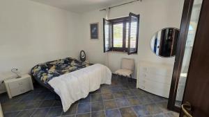 a bedroom with a bed and a mirror and a chair at La Maison de l'ile Bora in Policoro