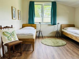 a bedroom with two beds and a window with blue curtains at Ferienhaus Marie in Wittenbeck