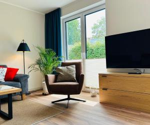 a living room with a television on a dresser at Ferienhaus Marie in Wittenbeck