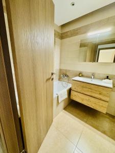 a bathroom with a sink and a mirror at Evoli Apartman in Debrecen +9 photos