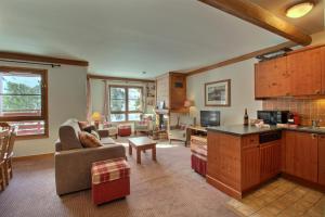 a kitchen and living room with a couch and a table at ARC 1950 - Appartement 10 personnes Duplex Cheminée - ski aux pieds - Sauna, Hammam, Jacuzzi, Piscine in Arc 1950