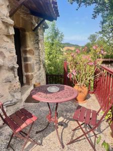 une table et deux chaises sur une terrasse dans l'établissement Aurifat, à Cordes-sur-Ciel