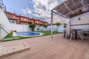 a patio with a table and chairs and a pool at Amplio chalet en un entorno natural y tranquilo in San Martín de Valdeiglesias