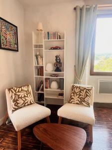 - un salon avec deux chaises et une étagère dans l'établissement Aurifat, à Cordes-sur-Ciel