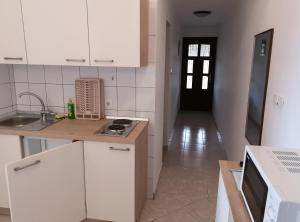 a white kitchen with a sink and a stove at Green Sea View Apartment in Premantura