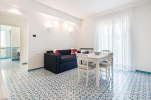 ein Wohnzimmer mit einem Tisch und einem Sofa in der Unterkunft Lea Residenza Mediterranea Paestum in Paestum