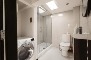 a bathroom with a washing machine and a toilet at Two Bedroom Executive Pad by Traboule Properties Ltd in Warrington