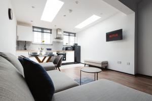 a living room with a couch and a kitchen at Two Bedroom Executive Pad by Traboule Properties Ltd in Warrington +14 photos